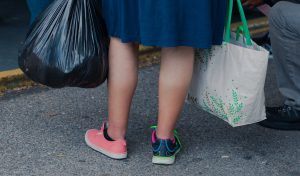 A client holds her things while waiting in line
