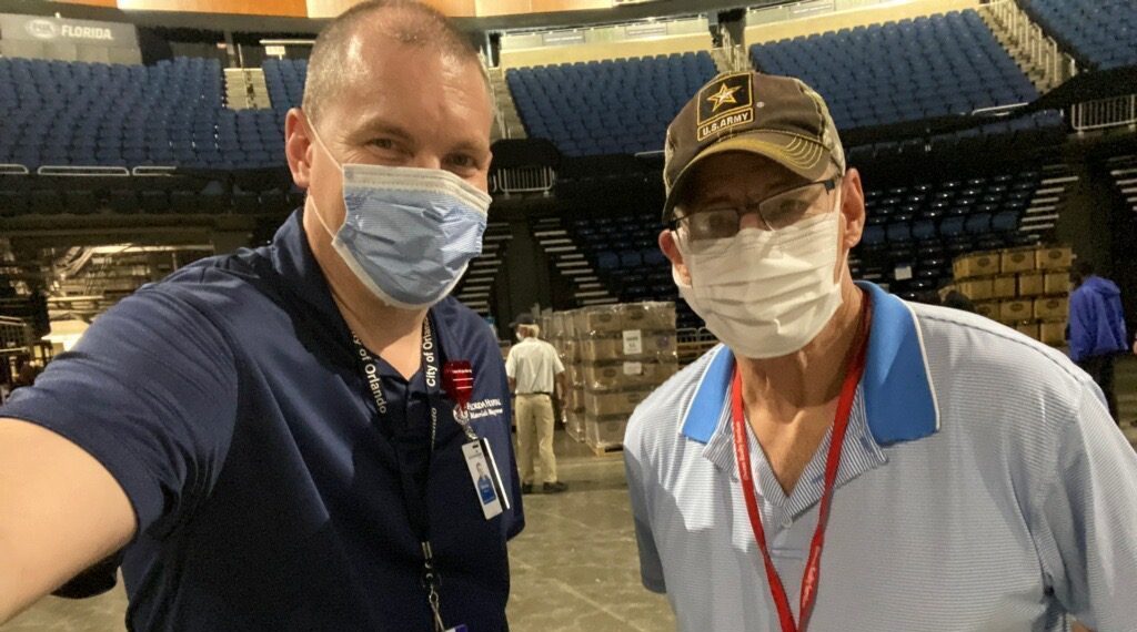IDignity board member Danny and former client Chris working to manage PPE at the Amway center