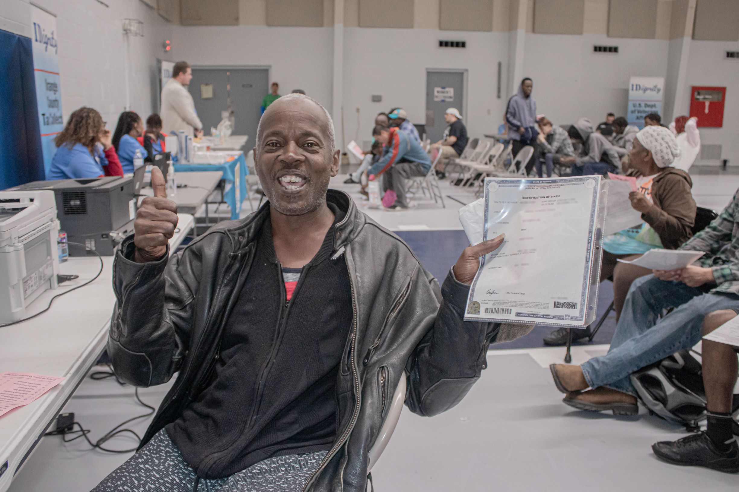 A client shows off his new birth certificate